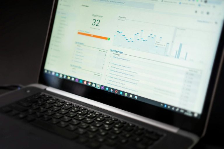 A laptop screen displays a website analytics dashboard showing real-time user data, pageviews, and a graph of activity statistics.